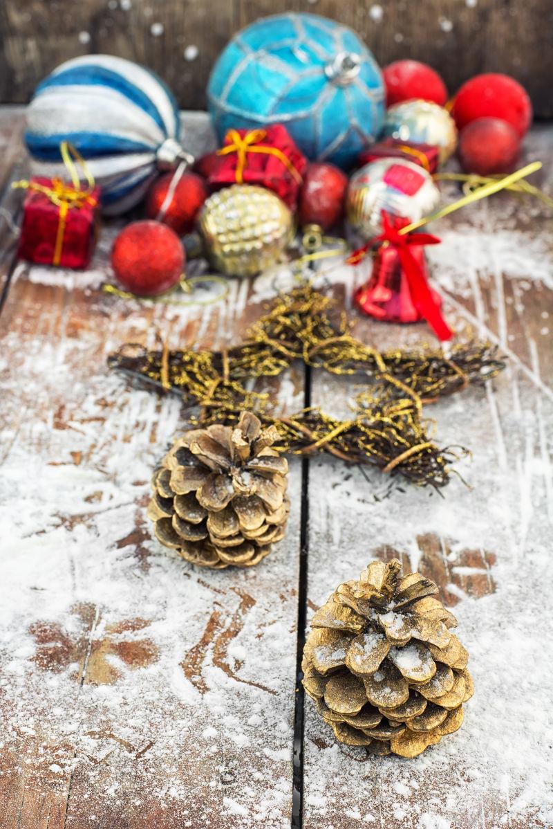 雪覆盖的圣诞饰品背后的两颗松果和玩具球