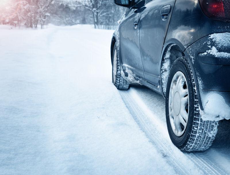 阳光下雪地上的汽车轮胎冬季特写