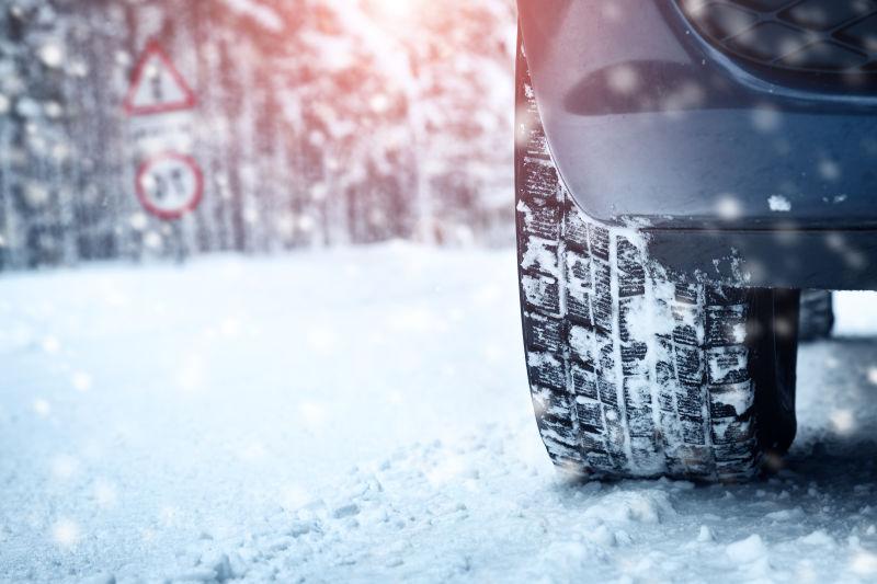 阳光下雪天路面上汽车的轮胎