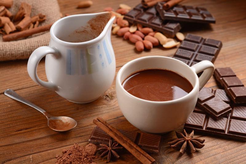 木桌上的巧克力调味料和装着热巧克力的杯子