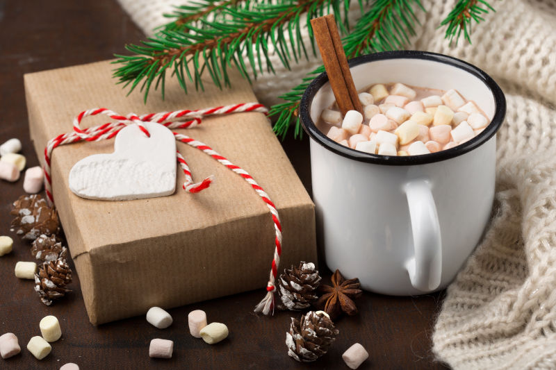 木板上的自制的圣诞热巧克力饮料和礼品盒