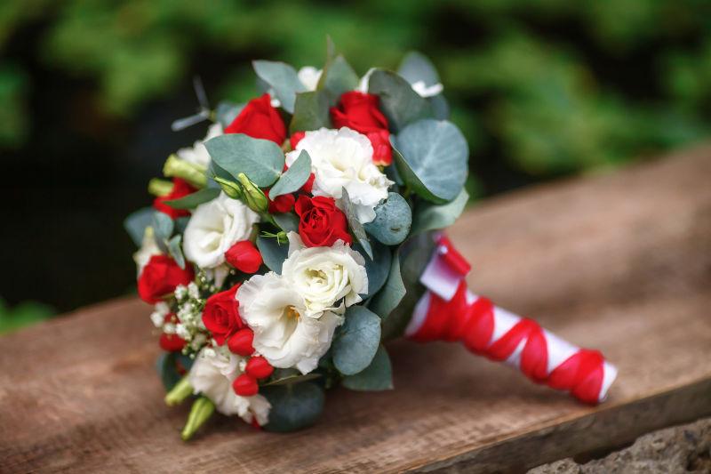 在木制背景下的美丽的玫瑰婚礼花束