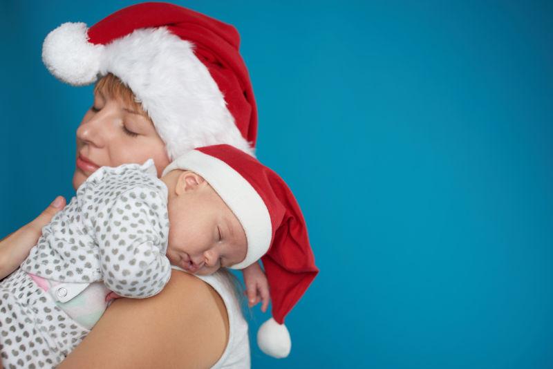 戴圣诞帽的年轻妈妈和可爱宝宝