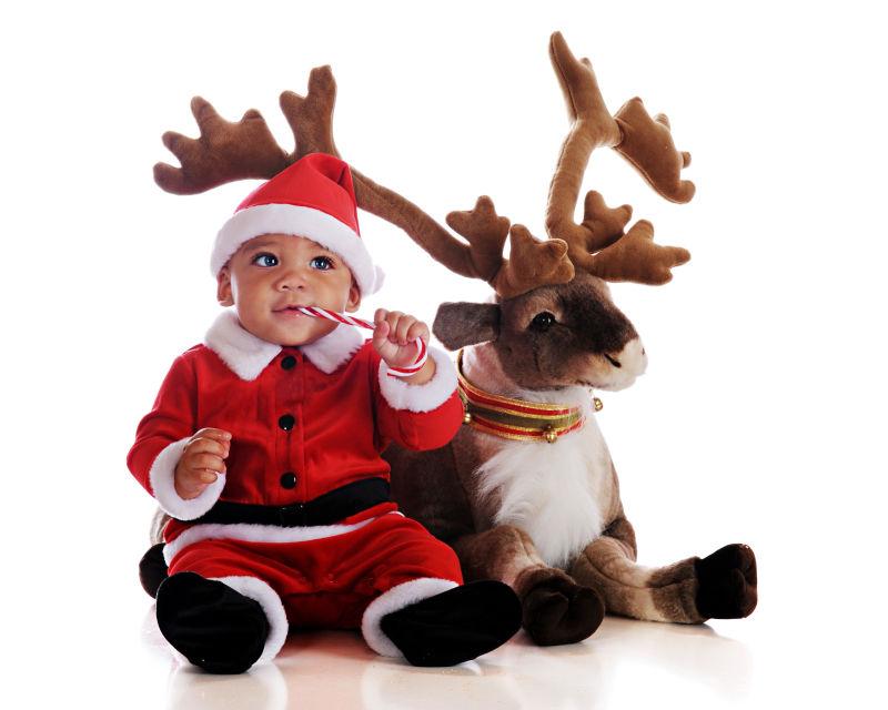 白色背景下吃糖果的圣诞宝宝和驯鹿