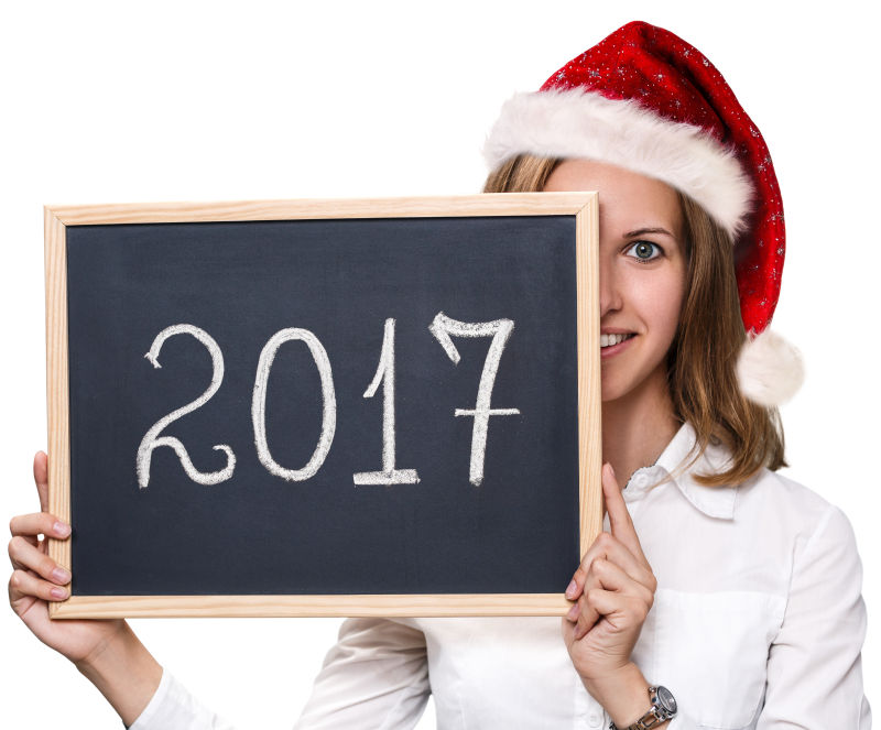 年轻女子带圣诞红帽子和黑板上的2017