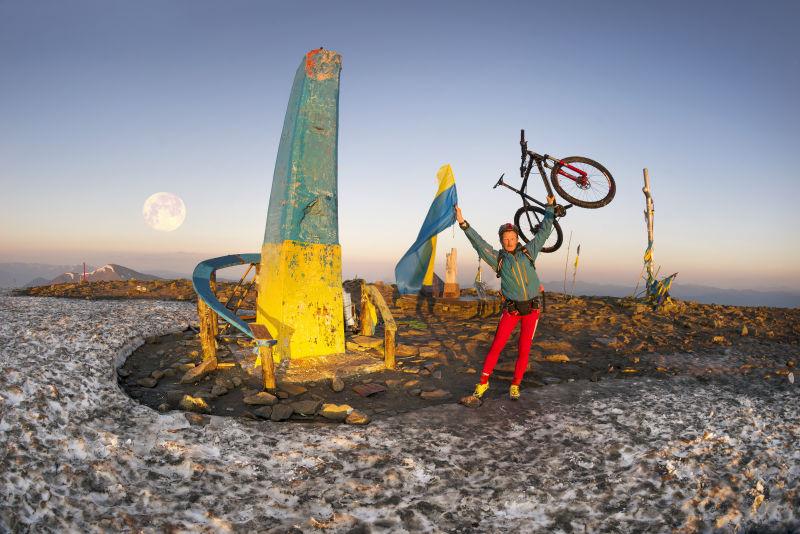 极限自行车运动员在山顶举起自行车
