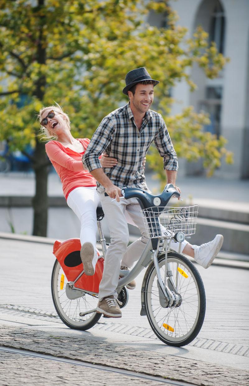夏天年轻夫妇在城里骑自行车