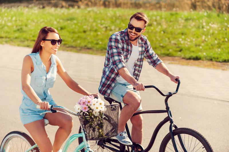 夏季年轻夫妇骑自行车在路上