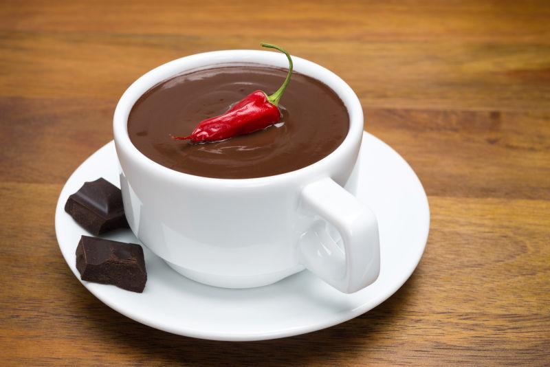 木制桌面上一杯用辣椒装饰的热巧克力