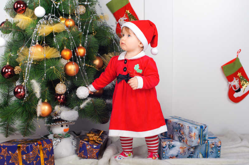 可爱的圣诞装扮的小女孩在圣诞树下