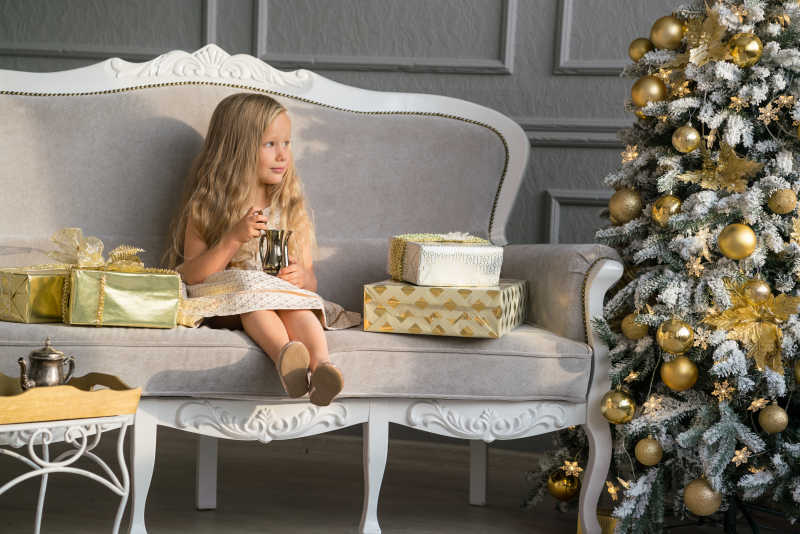 圣诞树旁的金发小女孩