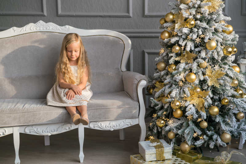 圣诞树旁可爱的金发小女孩