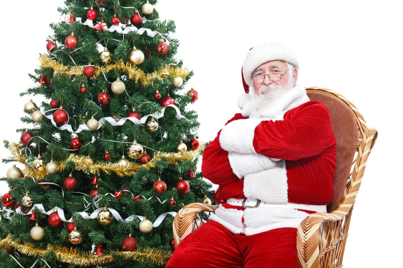 圣诞老人坐在圣诞树旁边