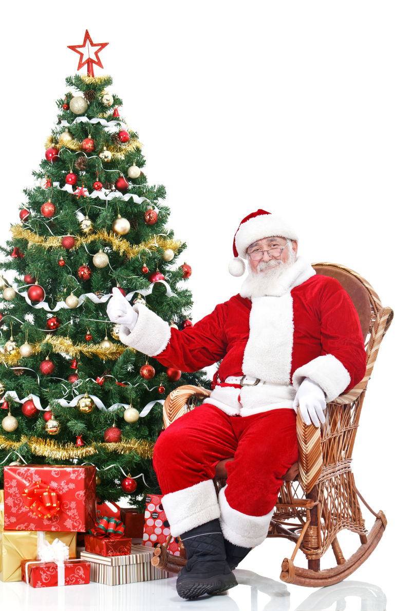 圣诞树旁边藤椅上的圣诞老人