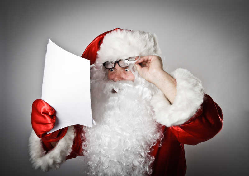 摘掉眼镜看书信的圣诞老人