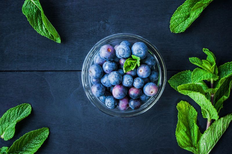深色背景上玻璃碗里的新鲜蓝莓