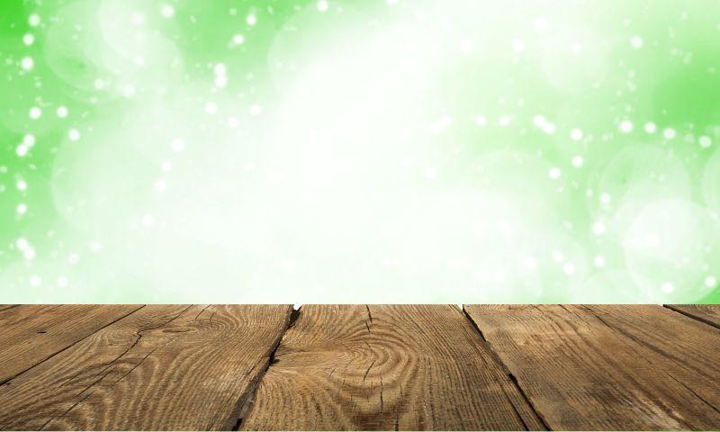 绿色斑点背景前的木桌