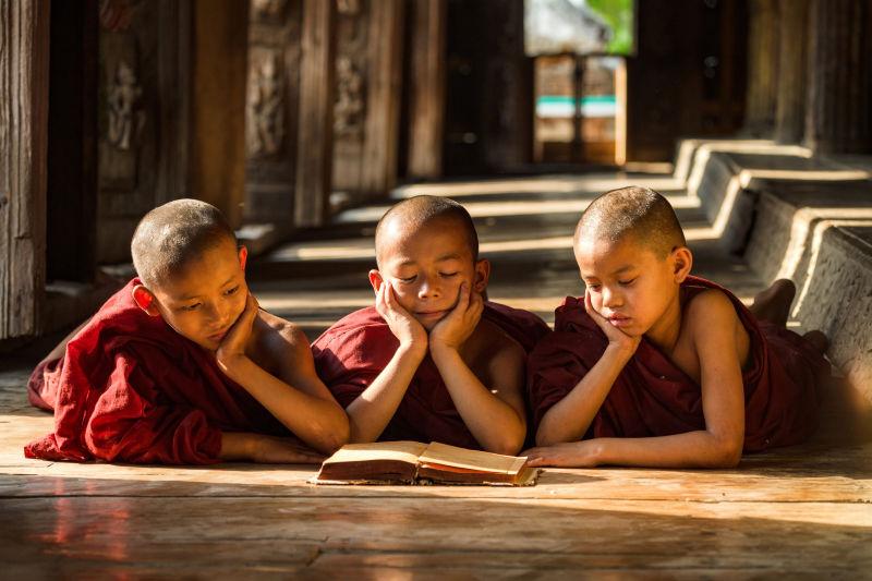 寺庙里三个年轻的僧人在看书